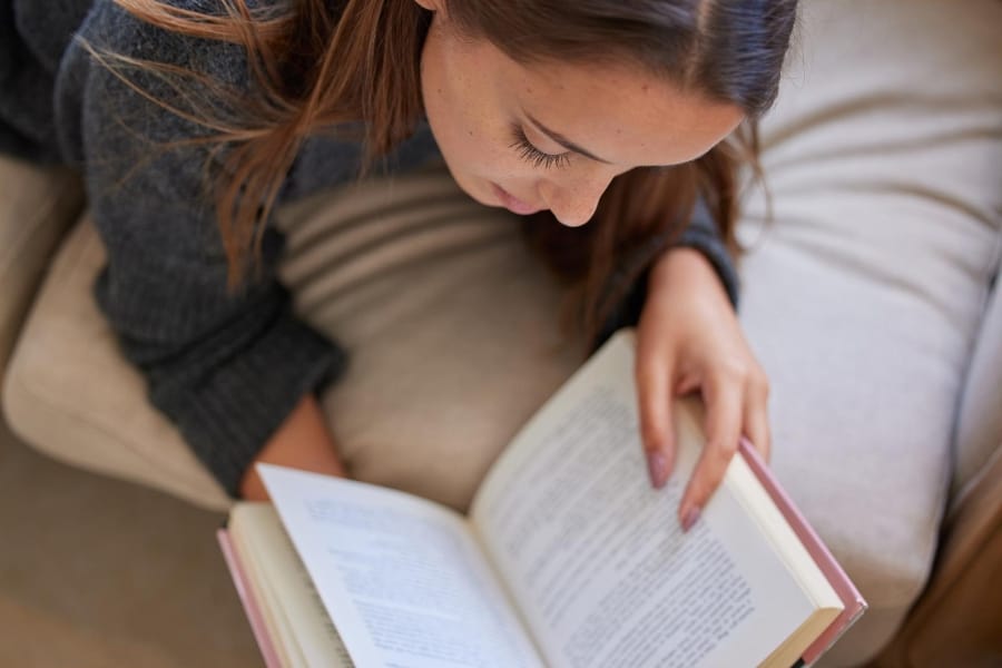 woman laying down reading a book