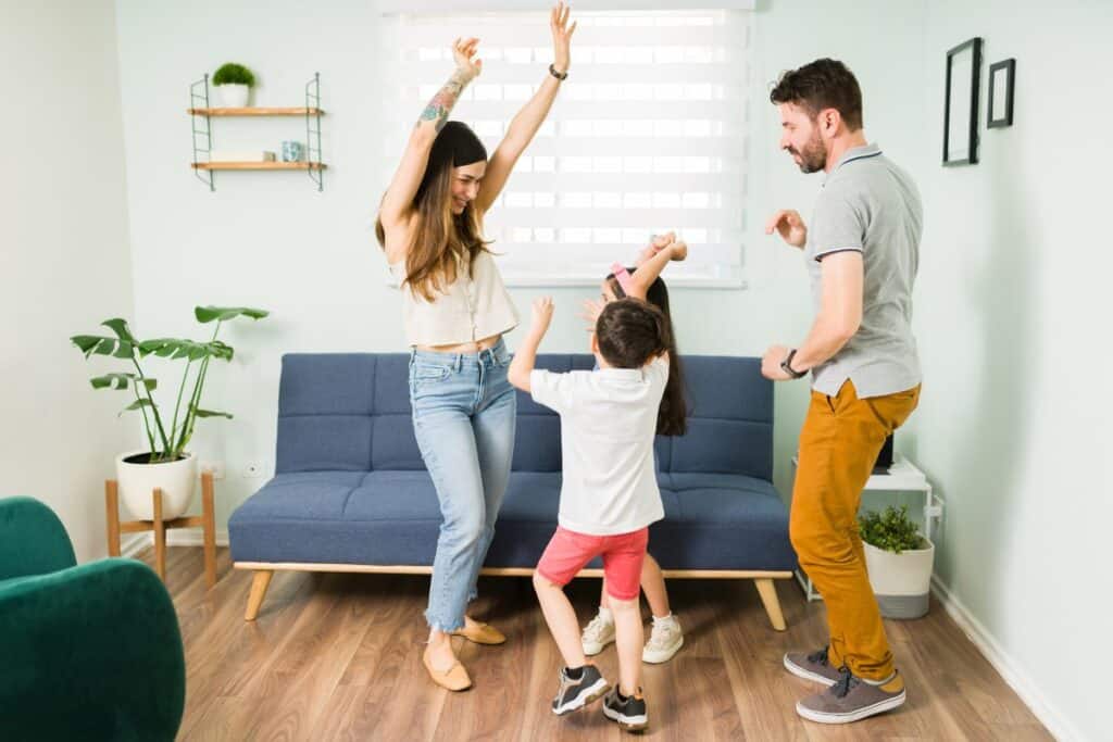 Mom, dad and child dancing around the room