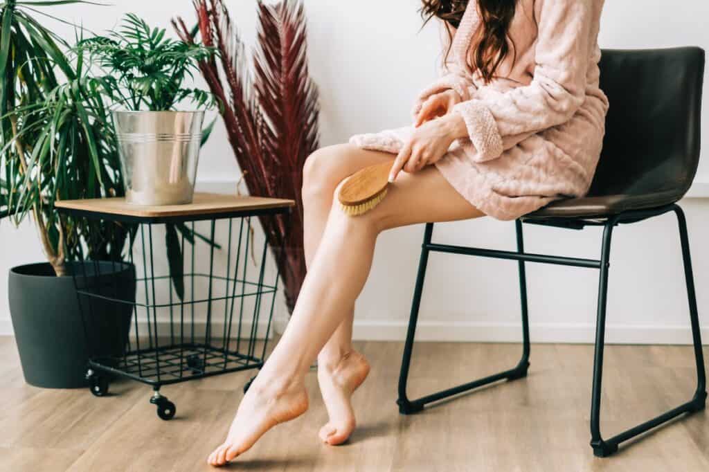 Women dry brushing her leg
