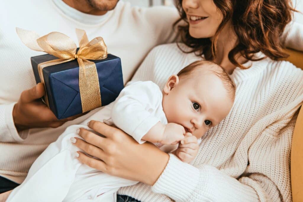 mom, dad, and baby with blue present