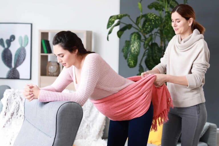 doula helping pregnant lady with a rebozo