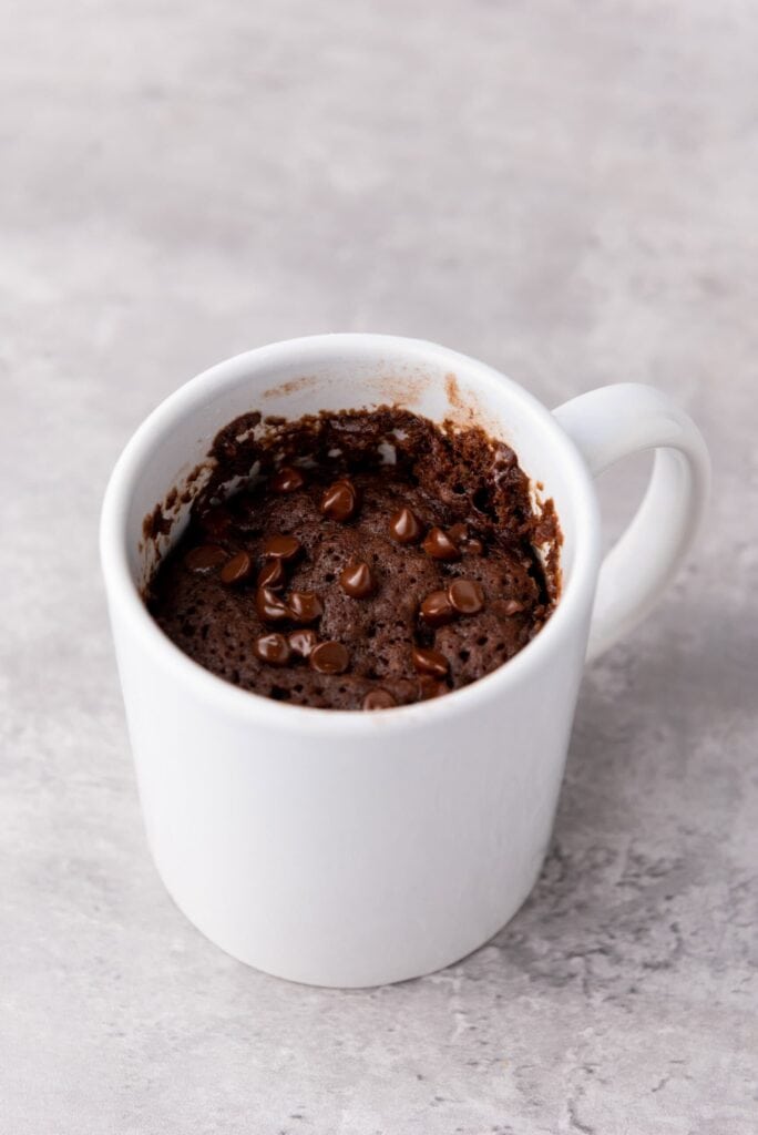 Chocolate chip brownie baked in a white mug.