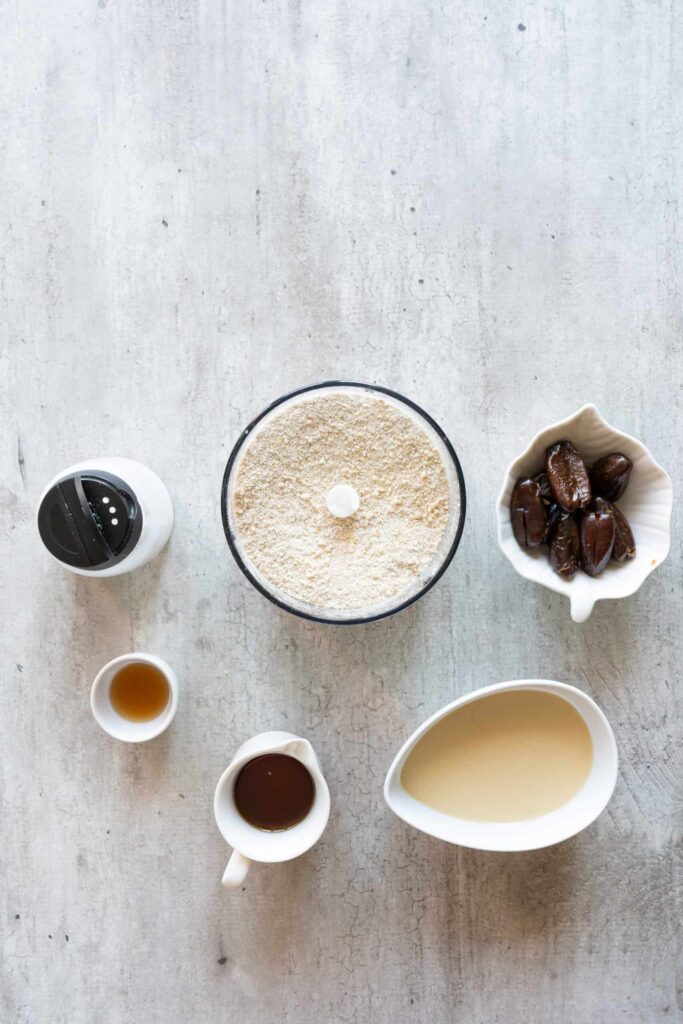 mixture of cashews and oats in a blender with other ingredients in the background