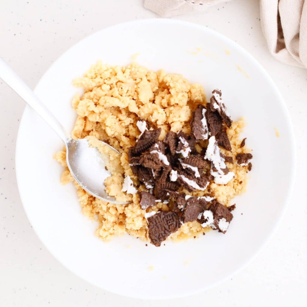 Edible Oreo cookie dough mixture on a white plate.