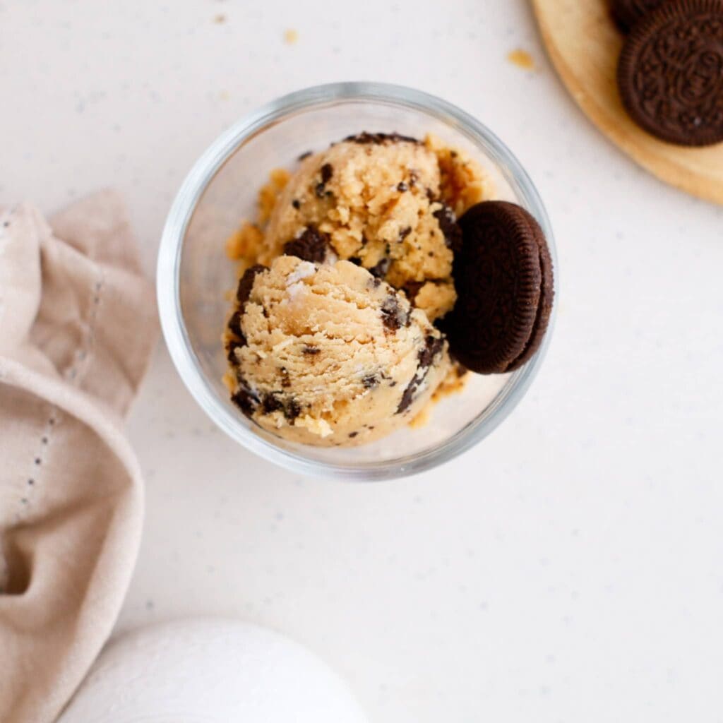 Edible Oreo cookie dough served in a glass with cookies on top, perfect for blood sugar-friendly sna.