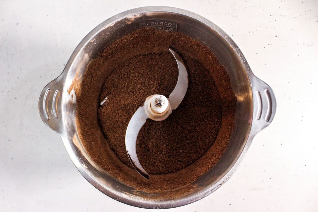 Blended chocolate protein brownie mixture in a food processor bowl ready to be shaped