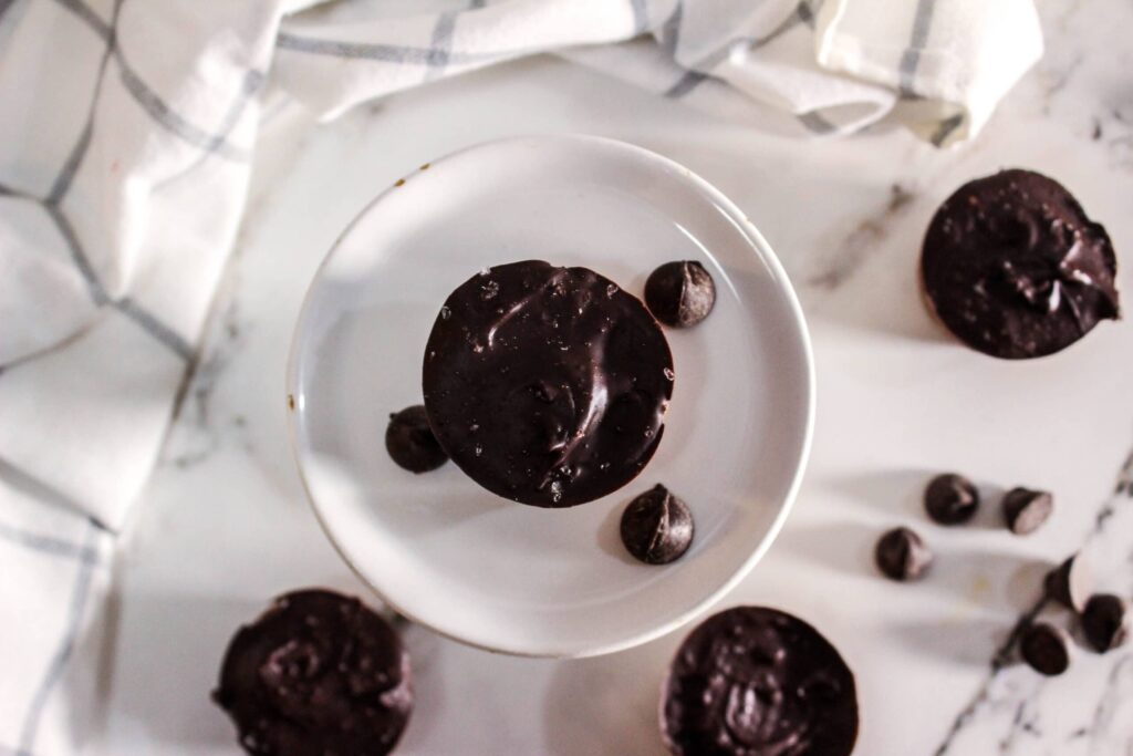 Delicious no-bake protein brownie bites with chocolate and blueberries on a white plate.