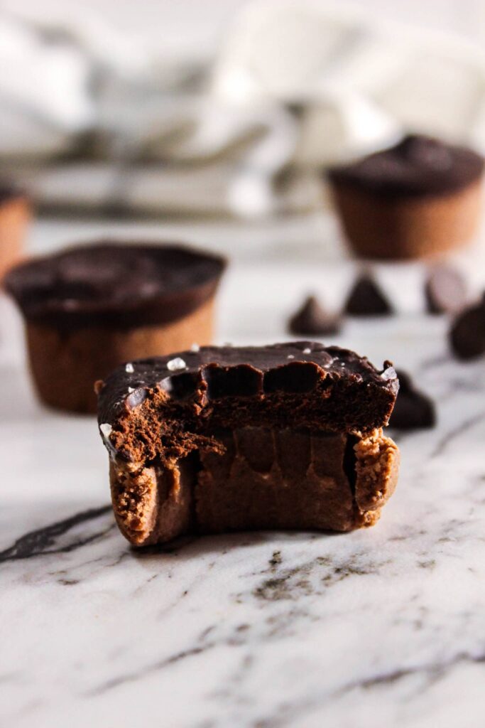Close-up of a bitten healthy protein brownie bite with chocolate topping, revealing a soft, gooey center