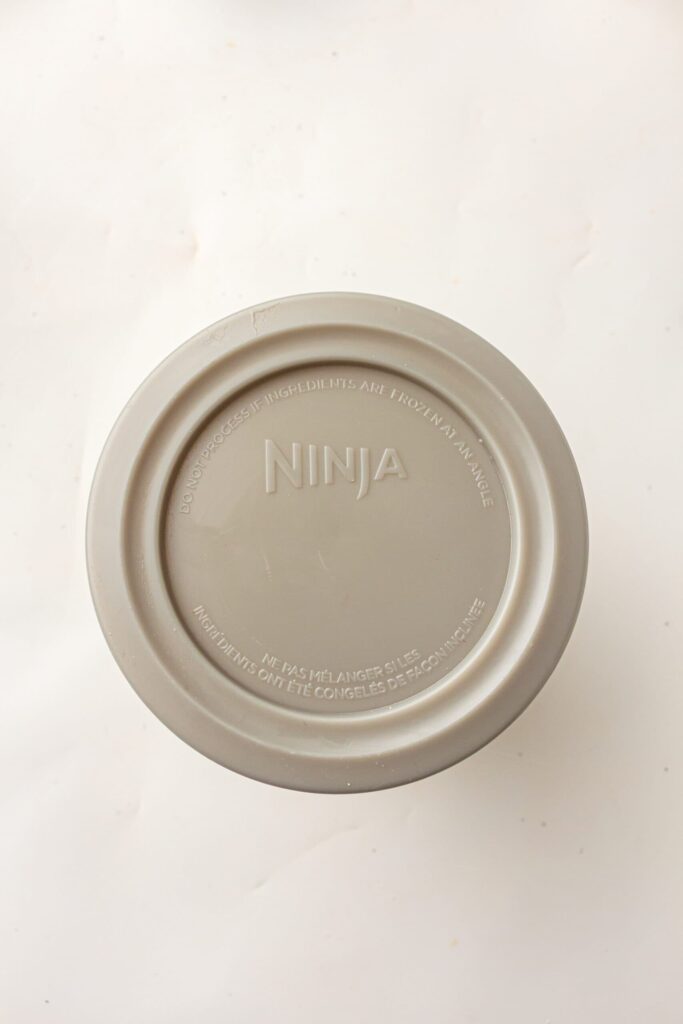 Securing the lid on the Ninja Creami container before placing it in the freezer.