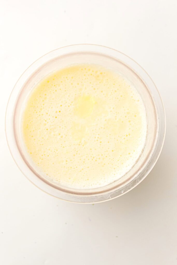 Frozen ice cream mixture set in the container, ready for processing.