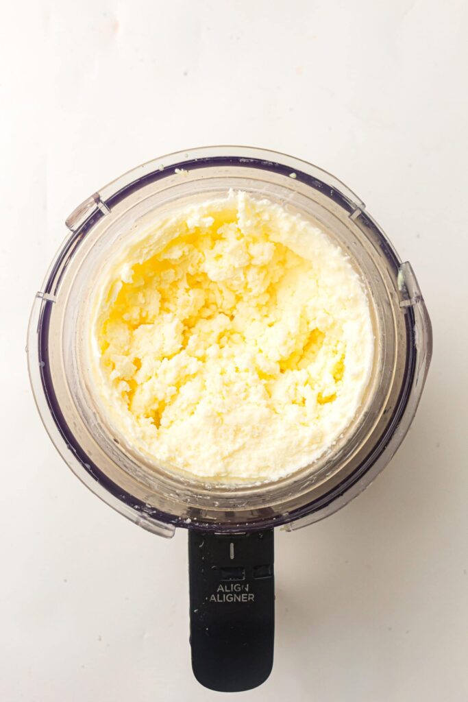 Processing the frozen mixture in the Ninja Creami and creating a hole in the center for mix-ins.
