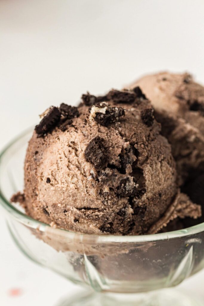 Delicious cookies and cream ice cream with cookie chunks in a glass bowl.